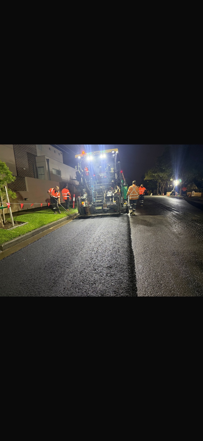 Asphalt paving crew working at night