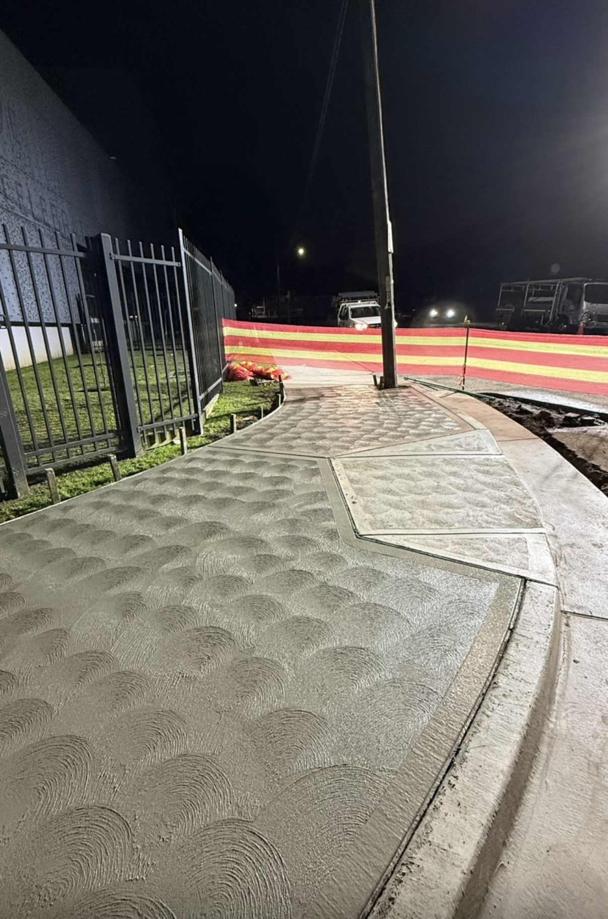 Detailed concrete footpath and kerb works at night